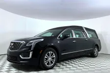 Thumbnail for Black Cadillac hearse with chrome details on a checkered floor in a white studio setting.