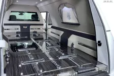 Thumbnail for Interior of a luxury hearse showcasing sleek design and refined materials with ample space.