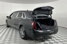 Thumbnail for Rear view of a black luxury limousine with an open trunk showcasing ample storage space.
