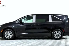 Thumbnail for Side view of a sleek black minivan with shiny wheels against a white background.