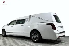 Thumbnail for White funeral hearse with sleek design, viewed from the side against a plain background.