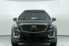 Thumbnail for Front view of a sleek black Cadillac SUV with distinctive grille and modern design features.