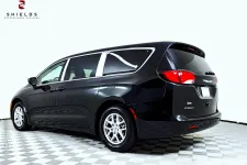 Thumbnail for Black Chrysler Pacifica minivan parked on a checkered floor with natural lighting.