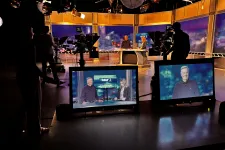 Thumbnail for a group of people standing around a display of televisions