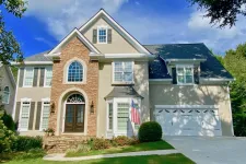 Thumbnail for a large brick house with a flag on the front