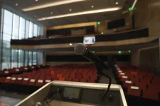 Thumbnail for a microphone on a podium in a room with red seats