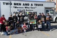 Thumbnail for a group of people posing for a photo in front of a truck