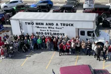 Thumbnail for a group of people standing next to a large white truck