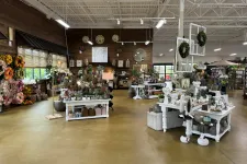 Thumbnail for Interior view of a rustic gift shop with floral arrangements, decorative clocks, and home decor items on display.