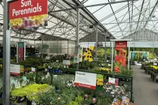 Thumbnail for Greenhouse section with diverse sun perennial plants and colorful signage at a garden center.