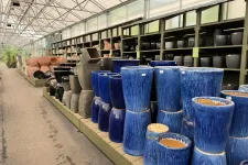 Thumbnail for Rows of various ceramic and pottery plant pots in different shapes and colors displayed in a garden center aisle.