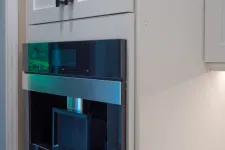 Thumbnail for Built-in modern Miele coffee machine integrated into white kitchen cabinetry with black handles.