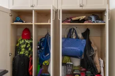 Thumbnail for Open beige closet with backpacks, shoes, hats, bags, and various stored items organized on shelves.