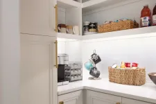 Thumbnail for Bright white pantry corner with shelves holding snacks, mugs, coffee machine, and woven baskets.