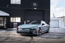Thumbnail for Silver Audi e-tron GT parked outside a black building with snowy ground and clear sky