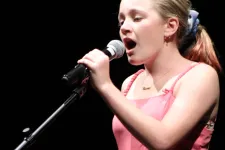 Thumbnail for a woman singing into a microphone