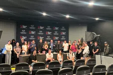 Thumbnail for Group of people posing in a studio with The Shrimp Tank branded backdrop and equipment around
