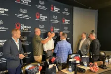 Thumbnail for Group of six men in business attire talking at The Shrimp Tank event with overlaid logo and text backdrop.