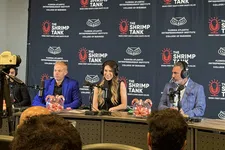 Thumbnail for Panel of three hosts with microphones and headphones at The Shrimp Tank event backdrop, engaging audience at conference.