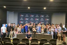 Thumbnail for Large group of people posing in front of a backdrop with The Shrimp Tank logo at an event or conference.