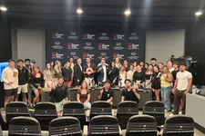 Thumbnail for Group photo of diverse young adults and presenters at The Shrimp Tank event in a studio with branded backdrop and seating.