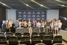 Thumbnail for Group of young adults and hosts posing in a studio set for The Shrimp Tank with branded backdrop and chairs.