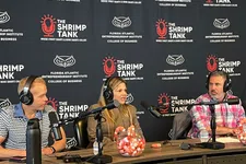 Thumbnail for Three hosts wearing headphones speak into microphones during a podcast recording at The Shrimp Tank studio.