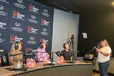 Thumbnail for Three panelists wear headphones and speak into microphones at The Shrimp Tank event with a woman standing nearby.