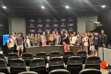 Thumbnail for Group of people posing in a studio with The Shrimp Tank logos behind a panel and empty audience seats in front.