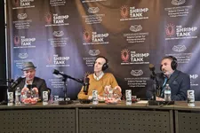 Thumbnail for Three men with headphones sitting at a table with microphones and candy jars during The Shrimp Tank event backdrop.