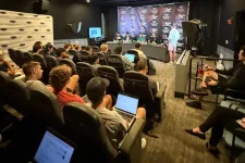 Thumbnail for Audience attending a podcast panel discussion in a small theater room with laptops and microphones setup
