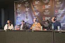 Thumbnail for Four podcast hosts wearing headphones and speaking into microphones at The Shrimp Tank event panel.