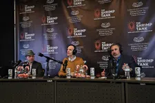 Thumbnail for Three men seated at a podcast table with microphones and branding backdrop for The Shrimp Tank event