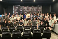 Thumbnail for Group of young adults and instructors posing for a photo in a studio with Shrimp Tank logos on the background.