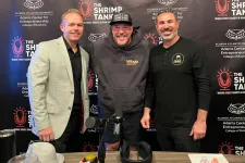 Thumbnail for Three men posing in front of The Shrimp Tank podcast backdrop at a recording table with microphones and refreshments.