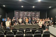 Thumbnail for Group of people posing inside a studio with Shrimp Tank media banners and theater-style seating in the foreground