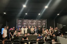 Thumbnail for Group of people posing in a studio with Shrimp Tank banners and professional lighting equipment in the background.