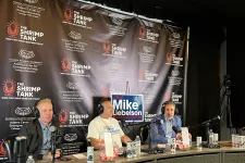 Thumbnail for Three men recording a podcast at The Shrimp Tank with microphones, headphones, and a campaign sign for Mike Rodelson.