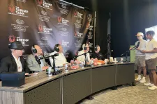 Thumbnail for Panel of five men recording a podcast at The Shrimp Tank event with two men hosting on the side.
