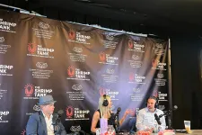 Thumbnail for Three people recording a podcast at The Shrimp Tank event with microphones and branded backdrop.