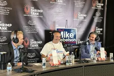 Thumbnail for Three men podcasting at The Shrimp Tank with campaign signs and branded backdrop for Mike Debelson for mayor.