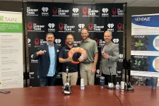 Thumbnail for a group of men standing next to a table with microphones