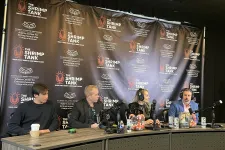 Thumbnail for Four people seated at a table with microphones, recording a podcast or panel discussion at The Shrimp Tank event.