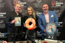 Thumbnail for Three people at a podcast table with microphones, holding books and a shrimp-shaped cushion, Shrimp Tank backdrop.