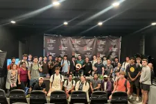 Thumbnail for Large diverse group posing in front of a Shrimp Tank banner in an indoor event space with studio lighting.