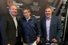 Thumbnail for Three men posing in front of The Shrimp Tank podcast backdrop with shrimp-themed props and microphones on a table