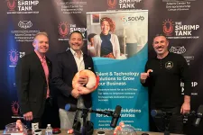Thumbnail for Three men posing with shrimp props in front of The Shrimp Tank podcast backdrop with promotional materials on table.