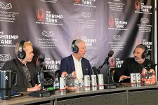 Thumbnail for Three men wearing headphones sit at a podcast table with microphones and a The Shrimp Tank branded backdrop.