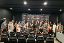 Thumbnail for Group photo of diverse young adults and professionals gathered in front of a Shrimp Tank event backdrop in a studio.