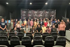 Thumbnail for Group of diverse young adults and instructors posing in front of a Shrimp Tank event backdrop in a conference room.